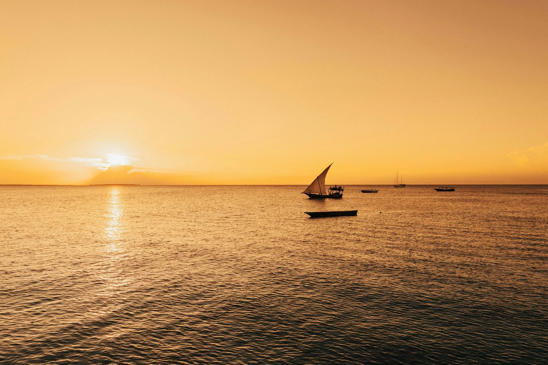 Silhouette of a dhow against the warm evening sky in Zanzibar